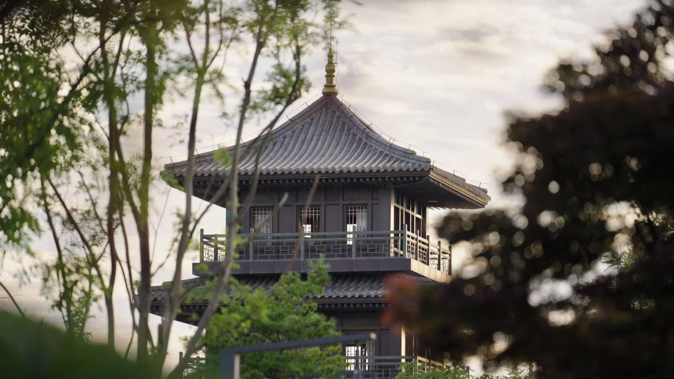 A traditional pagoda-style building with multiple levels and a tiled roof, surrounded by trees.