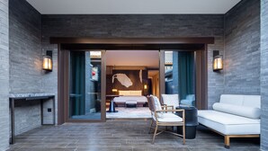 A modern hotel room with a large bed, a seating area with a sofa and chairs, and a fireplace. - JW Marriott Hotel Qufu (Jining)