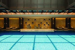 Relax in our spacious lobby with a large seating area and decorative vases, surrounded by a rectangular pool.