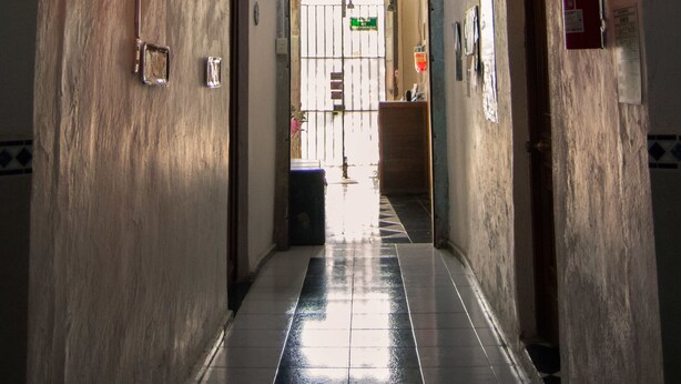 A hallway with a tiled floor, a wooden door frame, and hanging heart-shaped light fixtures.