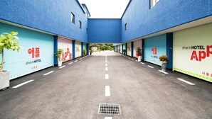 A drive-in hotel with a central courtyard, potted plants, and signage in a foreign language. - Apple Drive-in Motel (Yeoju)