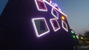 A hotel with illuminated geometric patterns on its facade. - Apple Drive-in Motel (Yeoju)