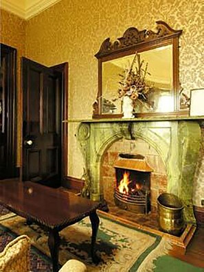 A room with a fireplace, a bench, and a mirror above it. - Ballinalacken castle country house hotel (Lisdoonvarna)