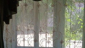 A window with decorative curtains featuring floral patterns. - Kok-Tobe Almaty Hotel (Almaty)