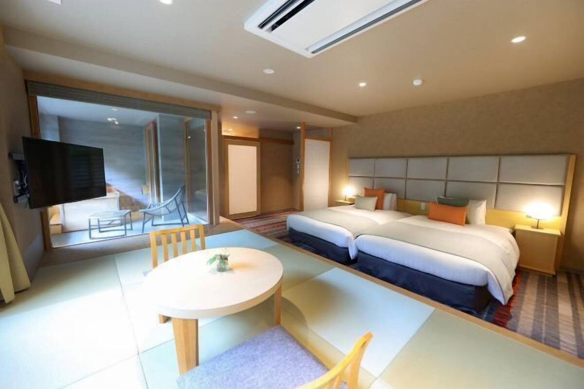 A hotel room with a large bed, a small table, and a TV.