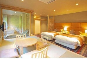 A hotel room with two beds, a sitting area with a table and chairs, and a television. - HAKONE YUYADO ZEN (Hakone)