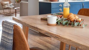 A cozy kitchen with wooden shelves, a dining table with chairs, and a breakfast setting. - Seascape Hideaways at Mortehoe (Woolacombe)