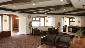 A spacious lobby with a fireplace, comfortable seating, and large windows. - Shirakabako View Hotel (Tateshina)