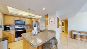 A modern kitchen with granite countertops, stainless steel appliances, and a central island.