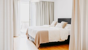A bedroom with a bed, curtains, and a hanging light fixture. - Landgut Riegerbauer (Feistritztal)