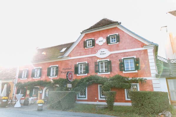 A red building with green shutters and a sign that reads "Gasthof". - Landgut Riegerbauer (Feistritztal)