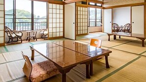 Una habitación japonesa tradicional con suelo de tatami, una mesa baja y puertas correderas.