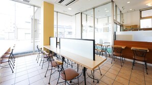 Un espacio de oficina moderno con una mesa grande, varias sillas y una pizarra.