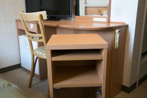 A compact hotel room with a wooden desk, a chair, a television, and a small refrigerator. - Hotel Econo Yokkaichi (Yokkaichi)