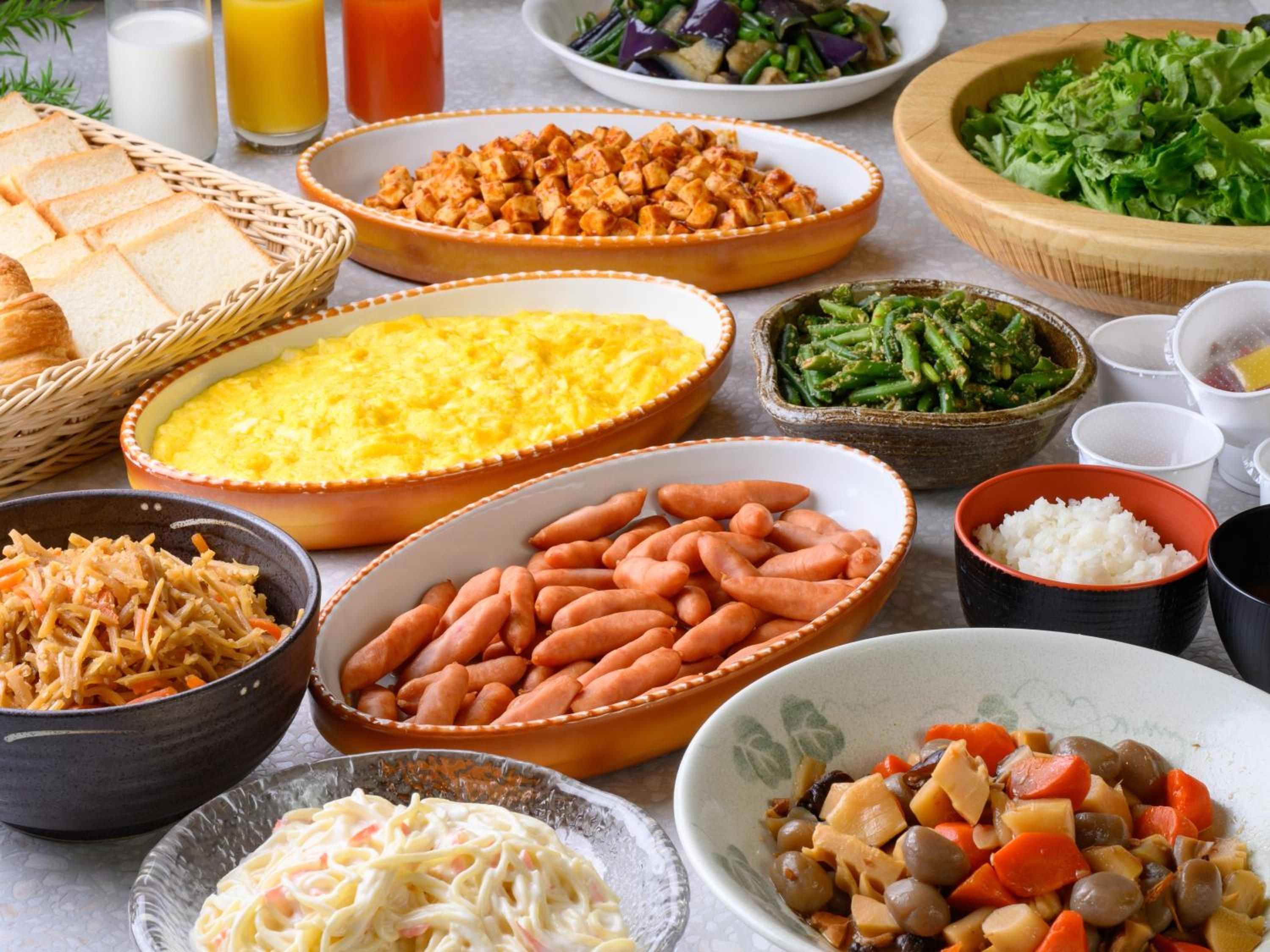 A variety of dishes including a bowl of rice, a dish with beans, and a plate of vegetables.