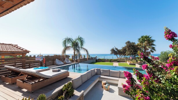 A pool area with lounge chairs and a view of the ocean. - Villa Del Nonno (Rhodes)