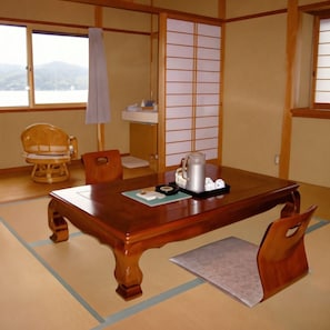 Una habitación japonesa tradicional con suelo de tatami, una mesa de madera y un panel shoji.