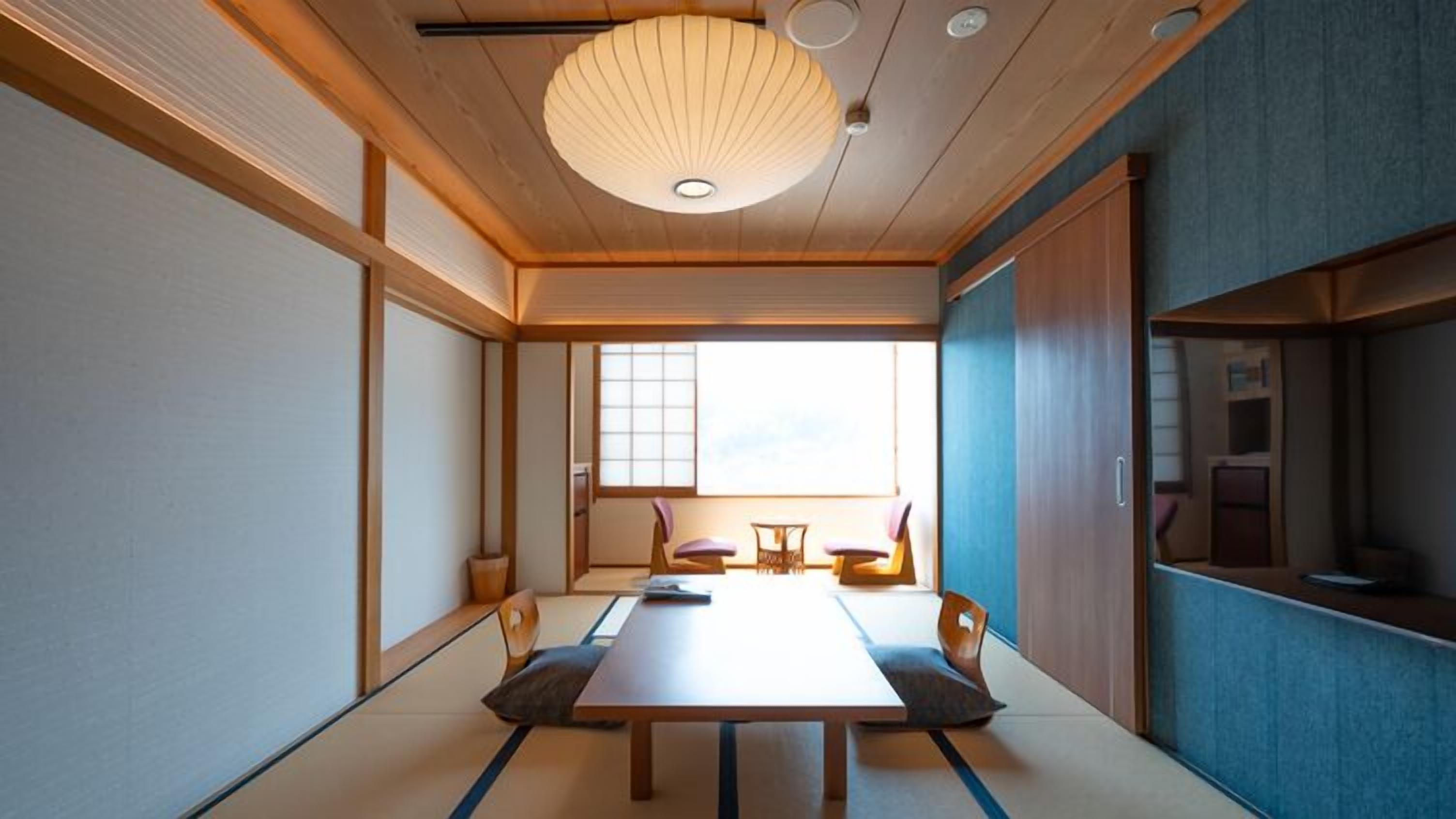 Une pièce de style japonais traditionnel, avec un sol recouvert de tatamis, une table basse et des portes coulissantes.
