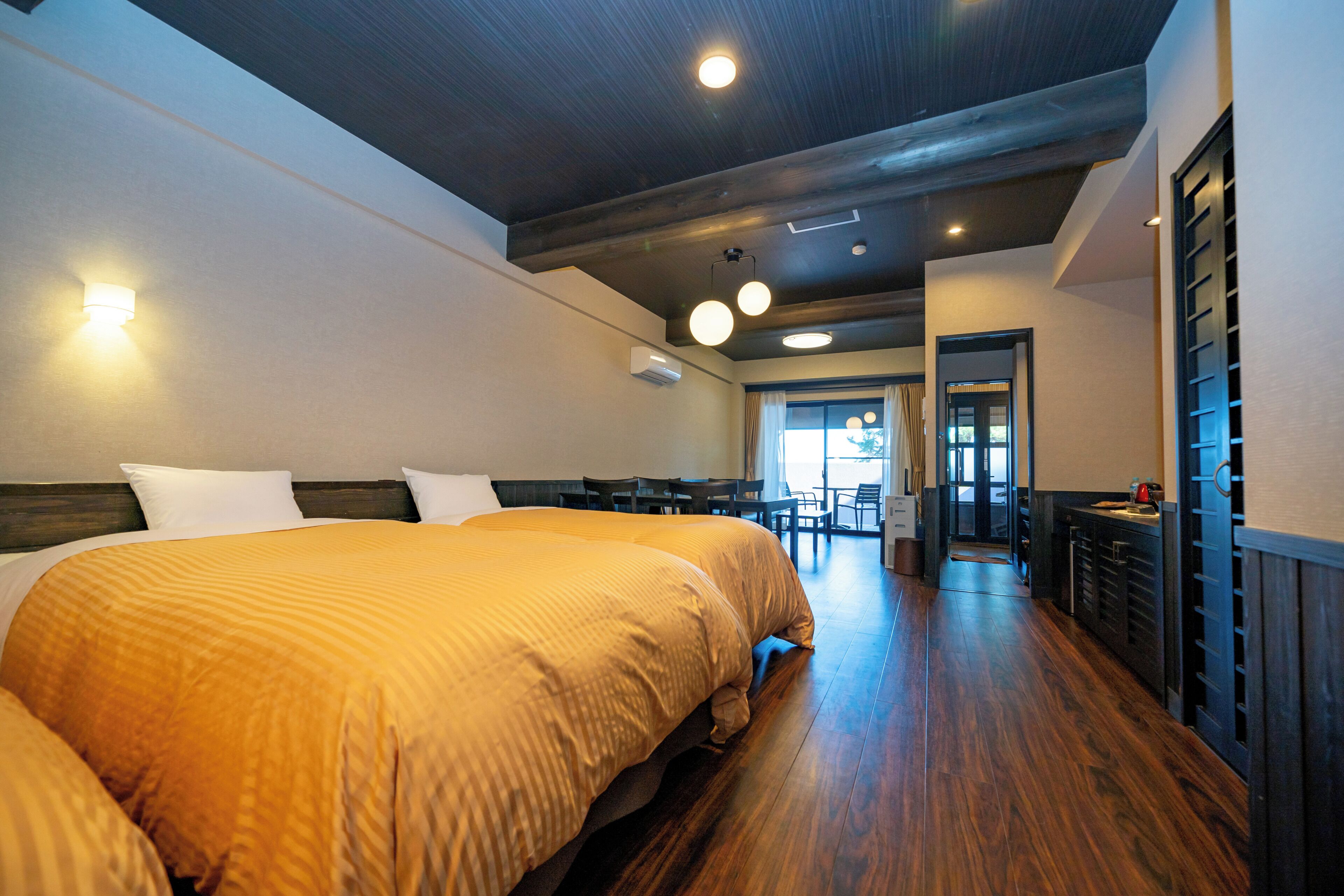 A hotel room with a large bed, a desk, and a chair.