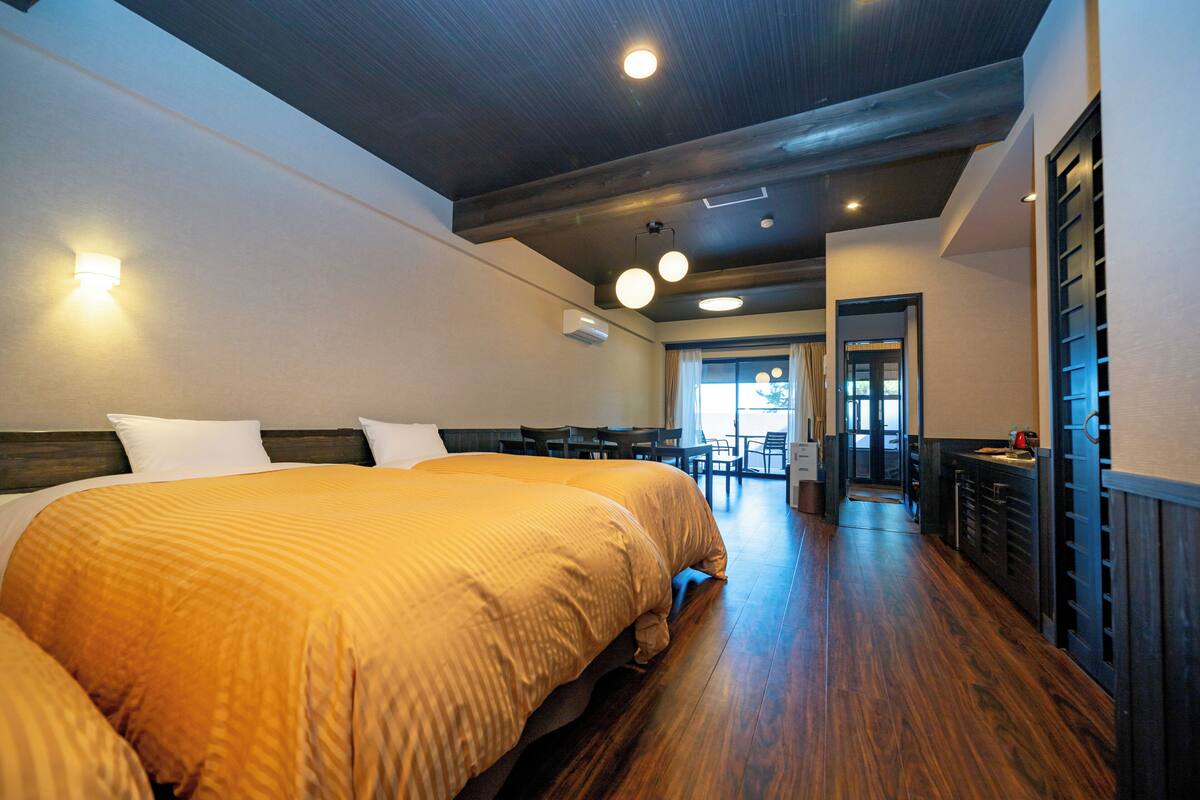 Quarto de hotel com uma cama grande, uma escrivaninha e uma cadeira.