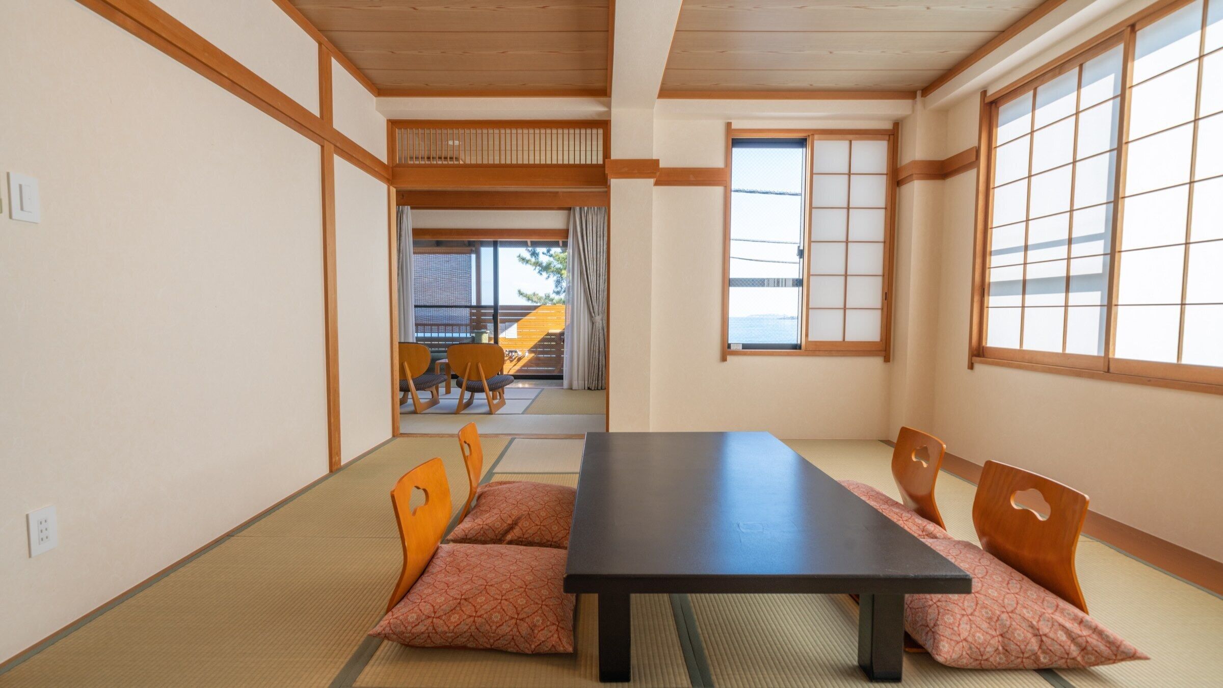 Une pièce de style japonais traditionnel, avec un sol recouvert de tatamis, une table basse et des portes coulissantes.