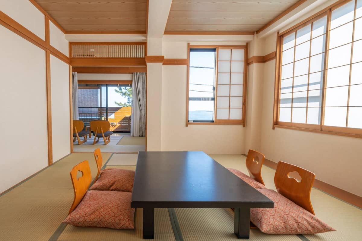 A traditional Japanese room with tatami flooring, a low table, and sliding doors.