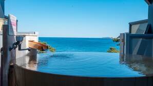 A infinity pool with a water feature, a view of the sea, and a building structure. - Atami Onsen New Tomiyoshi (Atami)