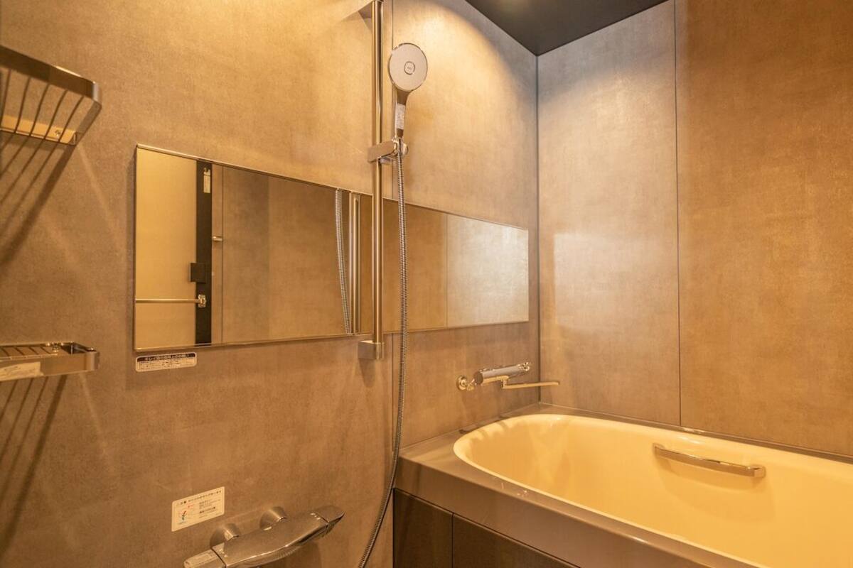 Uma casa de banho moderna com banheira, chuveiro e espelho.