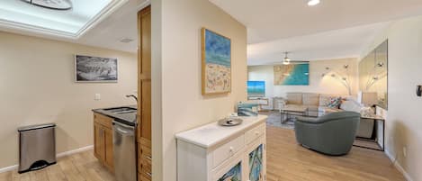 A modern living space with a kitchen, dining area, and a seating area with a sofa and a coffee table.