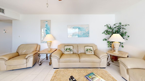 A living room with a beige sofa set, two side tables with lamps, a coffee table, and two wall-mounted paintings. - Gulf-Side Siesta Key Getaway with Beautiful Beach Views (Sarasota)