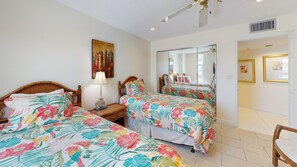 A hotel room with two beds, a large mirror, and artwork on the walls. - House Of The Sun #503GS (Sarasota)
