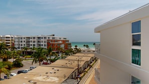 A hotel with a rooftop pool, a view of the beach, and a parking area. - House Of The Sun #503GS (Sarasota)