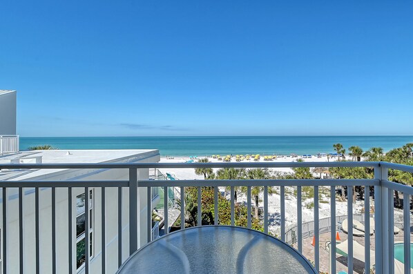 A balcony with a view of a beach and ocean.