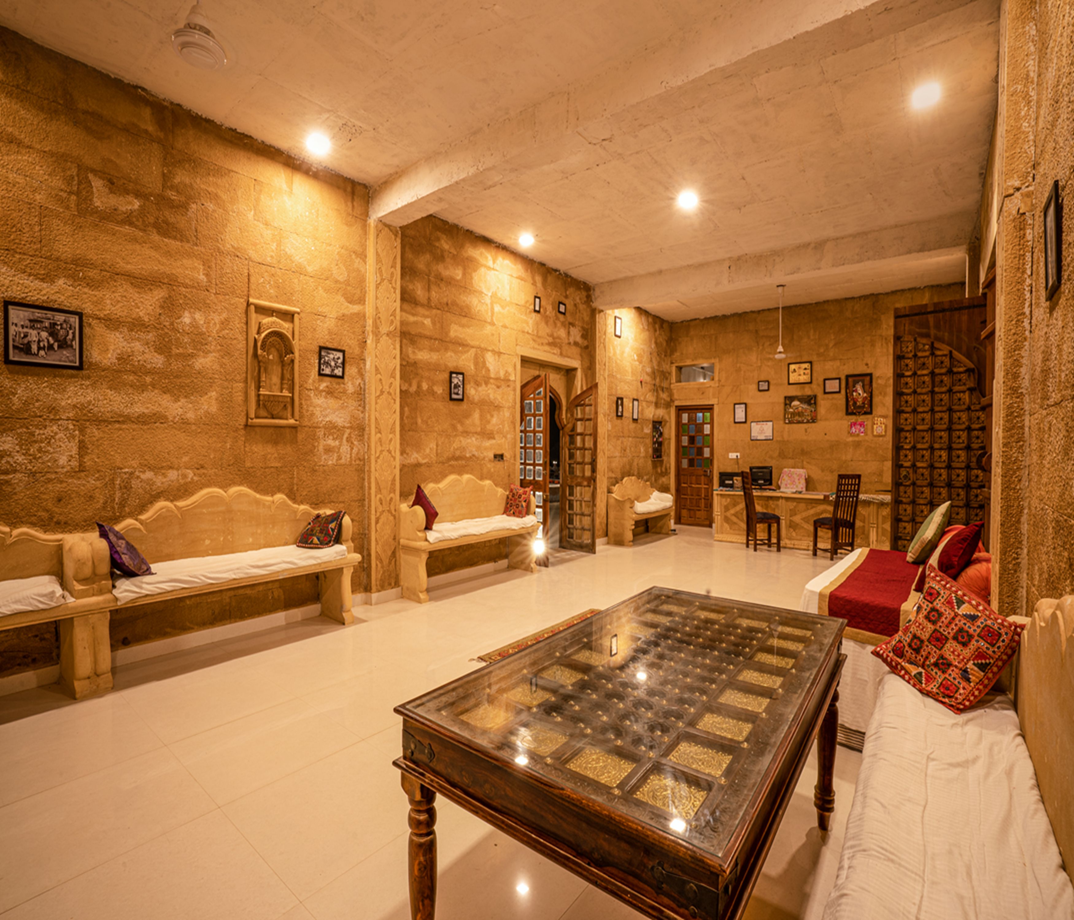A room with a large wooden table, two sofas, and a patterned wall.