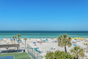 A beach with umbrellas, sun loungers, and a clear blue sky. - House Of The Sun #316GF (Sarasota)