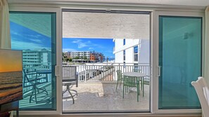 A balcony with a view of a building complex and palm trees. - House Of The Sun #303GS (Sarasota)