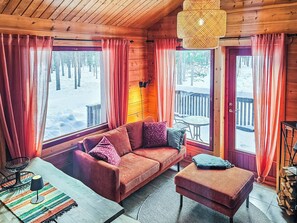 A cozy cabin interior with a sofa, a small table, and a bench.