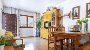 Un salon spacieux avec une table à manger en bois, un canapé et un meuble.