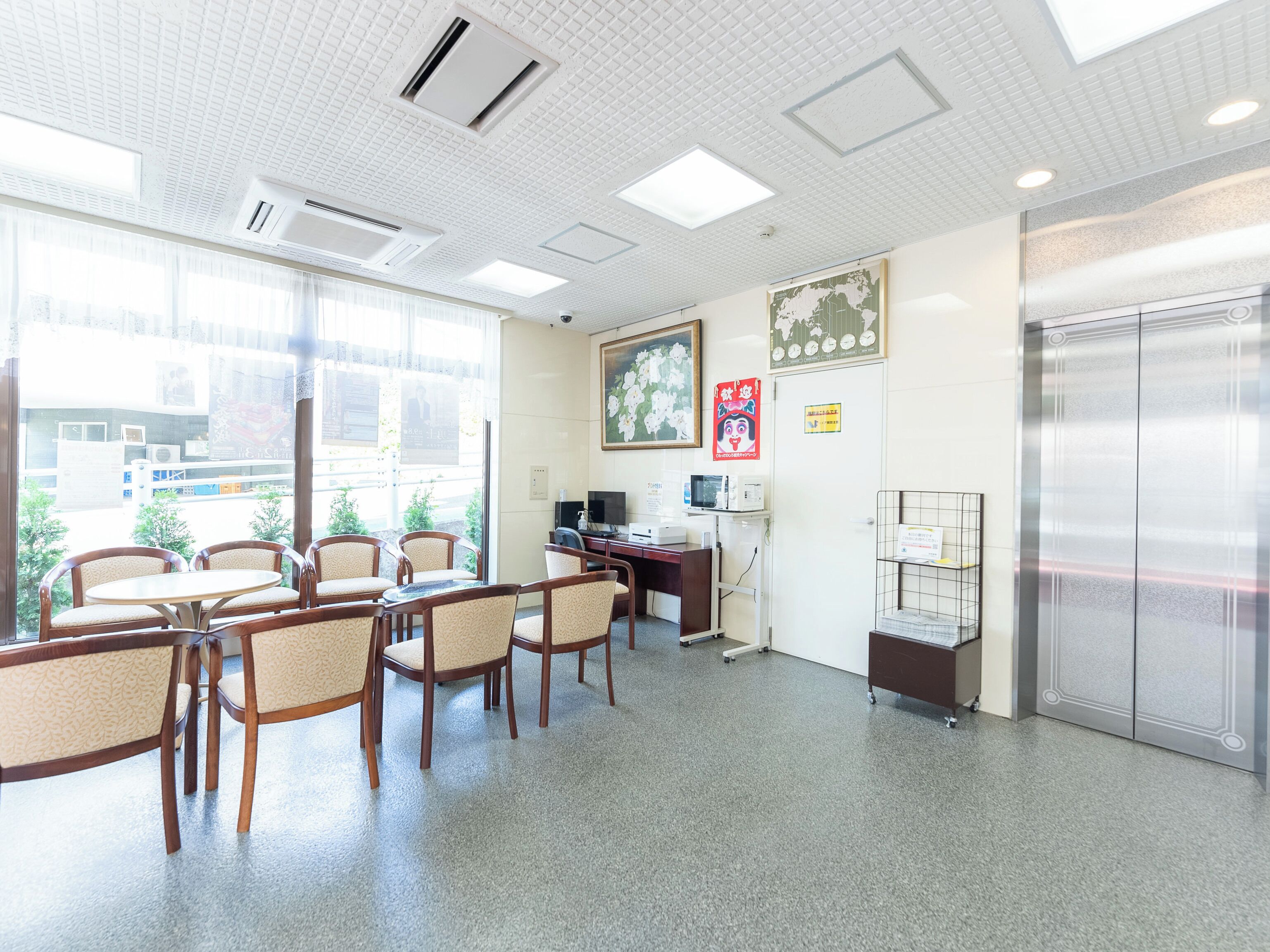 A hotel lobby with a reception desk, seating area, and an elevator.