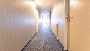 A long, narrow hotel corridor with carpeted floors and light-colored walls. - Noshiro Town Hotel Minami (Noshiro)
