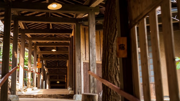A wooden interior with a central walkway, wooden beams, and a hanging sign.