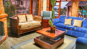 A living room with a sofa, armchair, and a coffee table. - Kalera Lodge - Equator Face (Cotacachi)