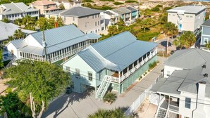 Un quartier résidentiel situé sur la côte, où les maisons se distinguent par leurs toits bleus et offrent une vue sur la plage.