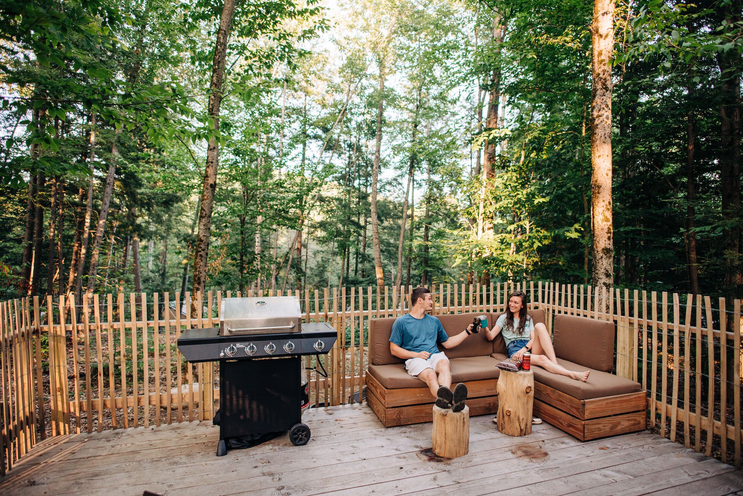 A wooden deck with a barbecue grill and a sofa.