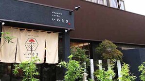 Un bâtiment à la façade noire, sur lequel on peut voir une enseigne avec des caractères japonais.