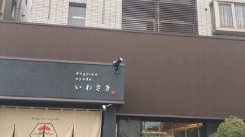 Un edificio con fachada moderna, que presenta un ventanal grande y un letrero con caracteres japoneses.