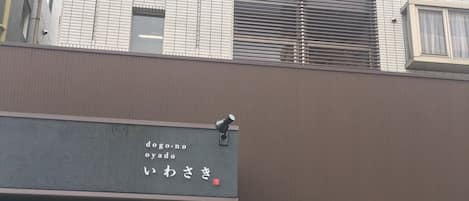 Un edificio con fachada moderna, que presenta un ventanal grande y un letrero con caracteres japoneses.