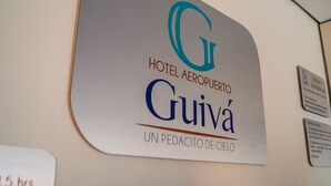 Un panneau indiquant l’hôtel Aeropuerto Guivá, avec un logo et le nom de l’hôtel.