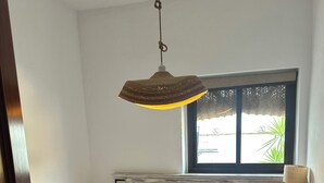 A bedroom with a bed, a window with a view, a nightstand, and a hanging light fixture. - La ZÚA Rural Cottage in the Molino el Vado estate (Villamartin)