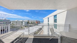 A balcony with a view of a beach and buildings. - House Of The Sun #501GS (Sarasota)